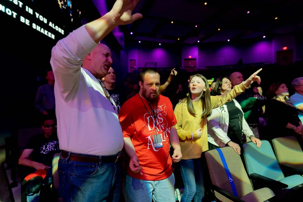 Friends worshipping together with hands raised